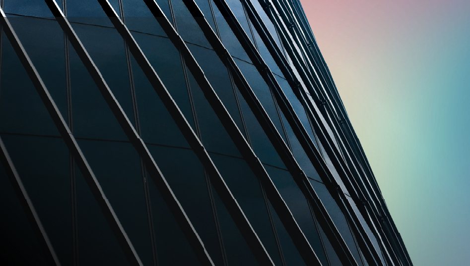 Fachada vidriada de una torre corporativa al atardecer
